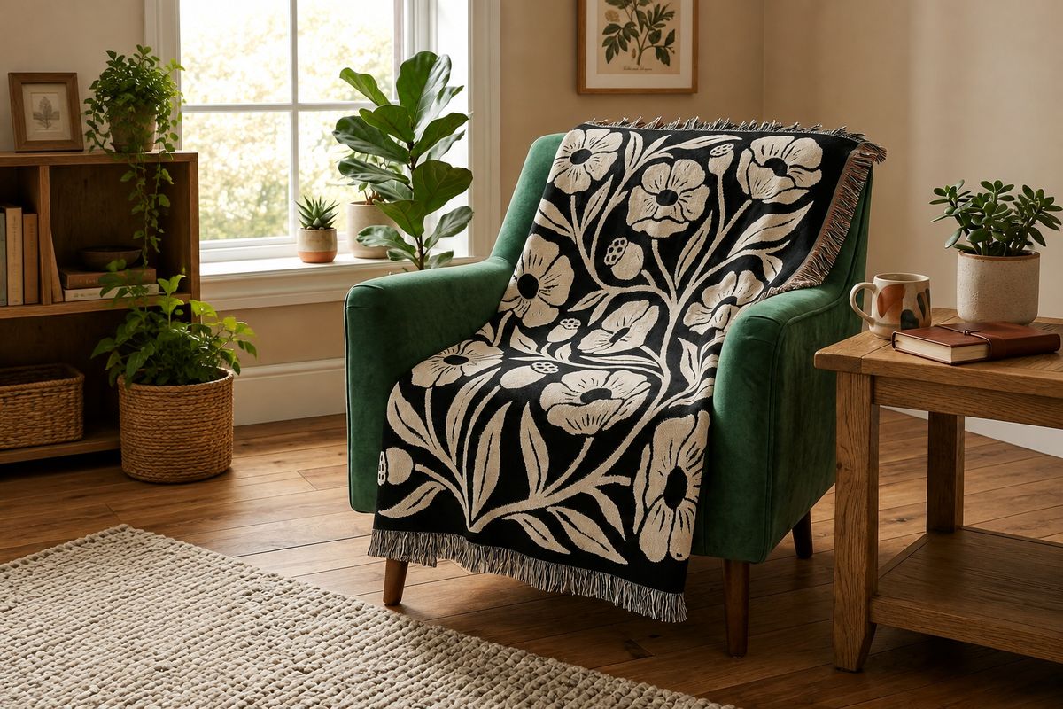 Black and cream oversized poppy woven blanket styled on a green reading chair