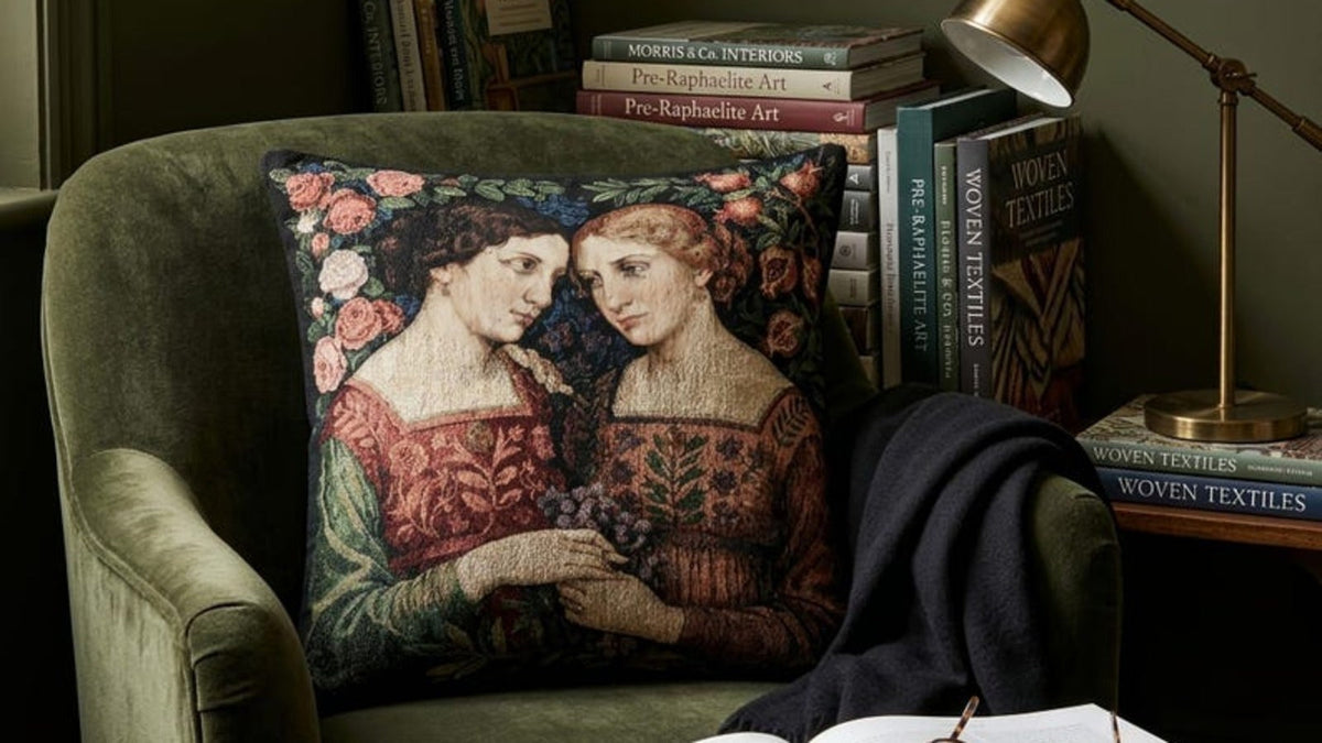 Sapphic Pre-Raphaelite woven pillow styled in a dark green reading chair