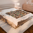 Botanical folk-art plush blanket layered on a neutral bed