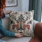 Person holding the Christmas deer and cardinal woven pillow