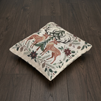 Angled view of Christmas deer woven pillow on a wood floor