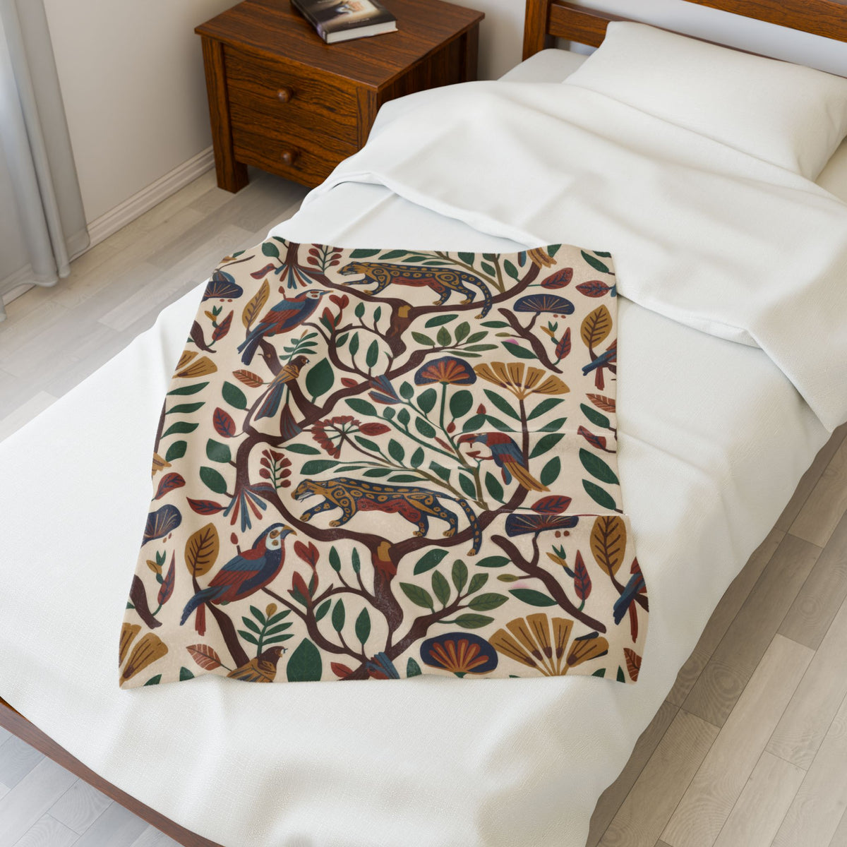 Tropical folk-art plush blanket folded across a white bed