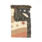 Folded celestial blanket showing woven texture, reverse, and fringe