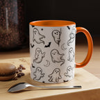 White Halloween accent mug with hand-drawn ghosts and orange trim