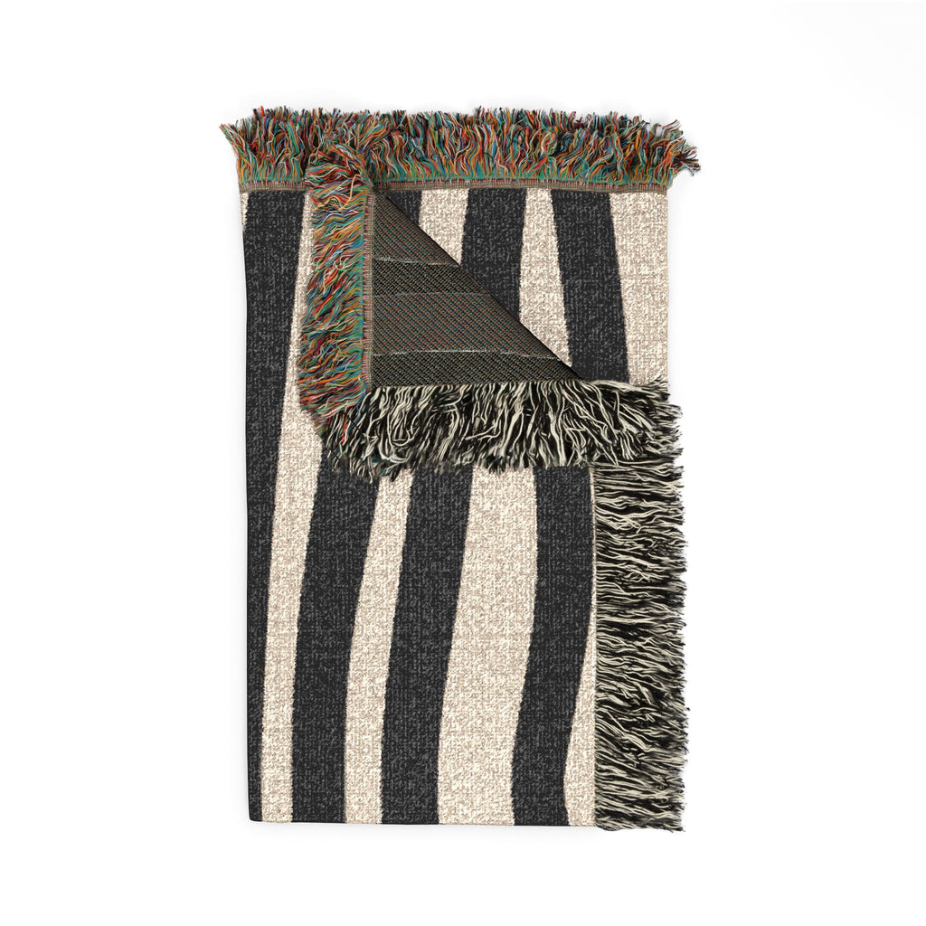 Folded abstract stripe blanket showing woven texture and fringe