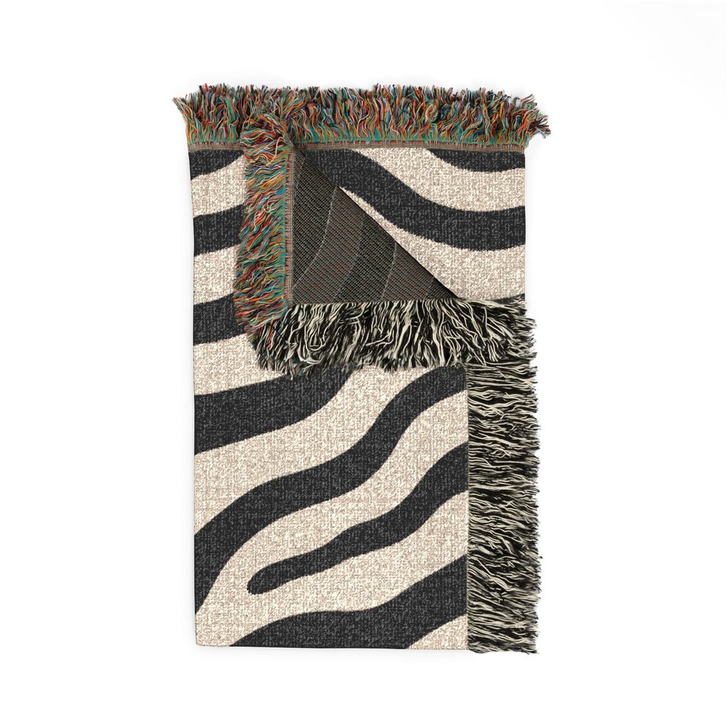 Folded zebra print woven blanket showing texture, reverse, and fringe