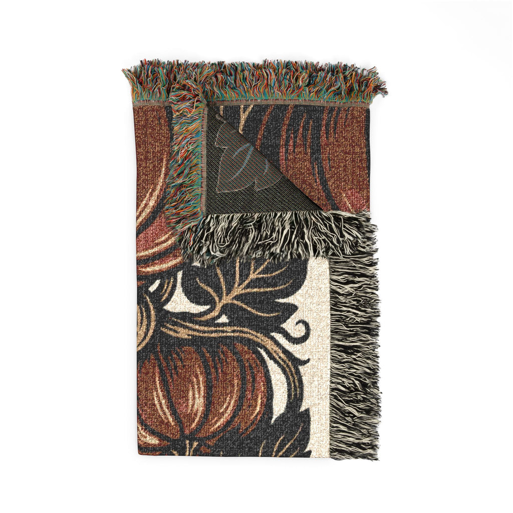 Folded botanical pumpkin blanket showing woven texture and fringe