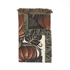 Folded botanical pumpkin blanket showing woven texture and fringe