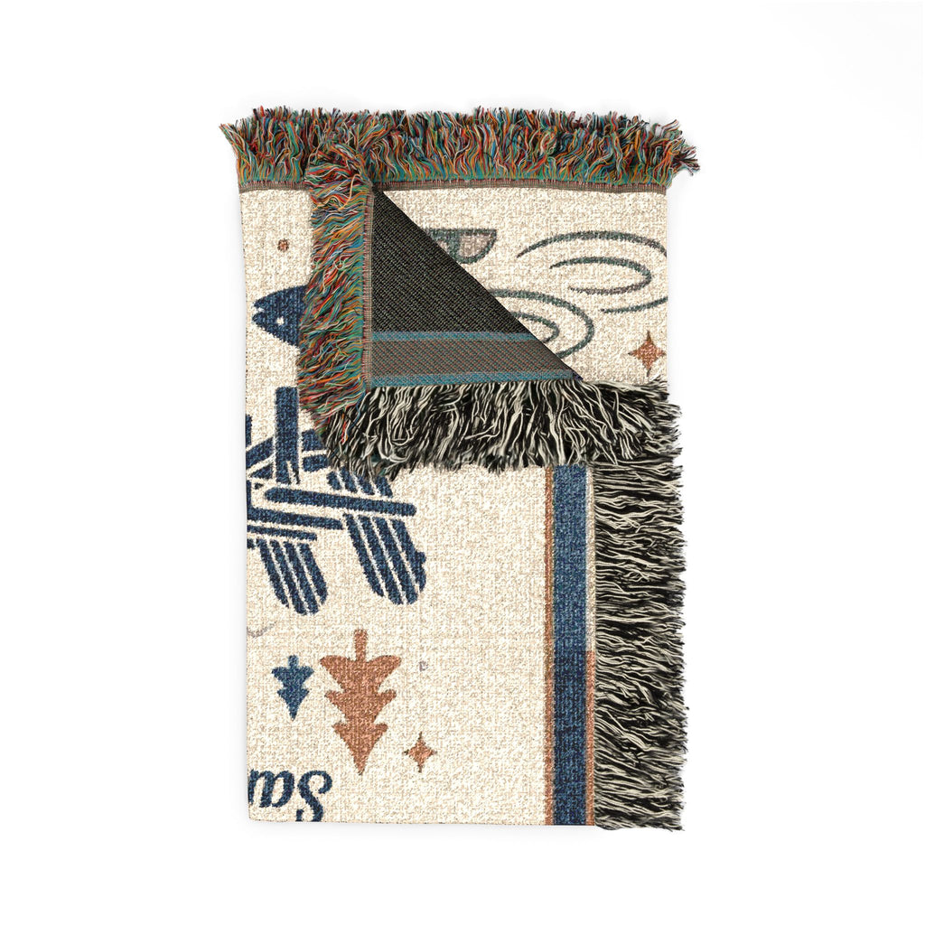 Folded cotton woven blanket showing tapestry texture, reverse and fringed edges