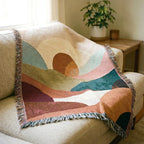 Earth-tone abstract sunset landscape woven blanket with layered hills