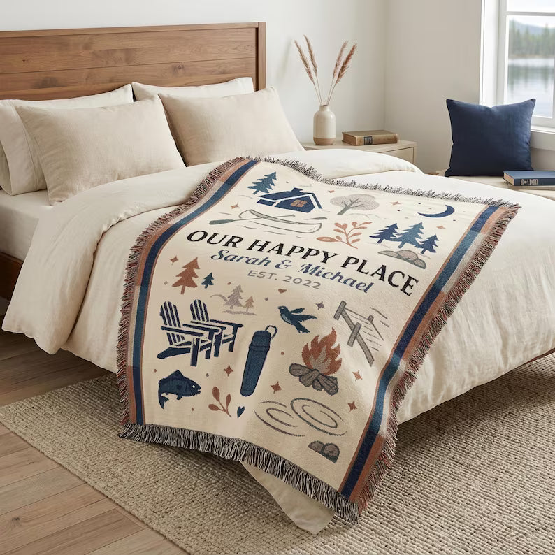 Personalized cabin and camping woven blanket styled across a bed