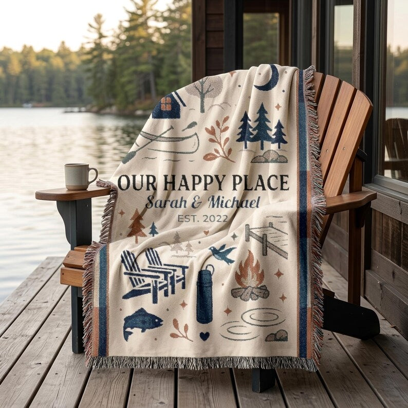 Our Happy Place woven blanket on an Adirondack chair by a lake