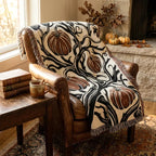 Gothic rust pumpkin and black botanical throw styled on a chair