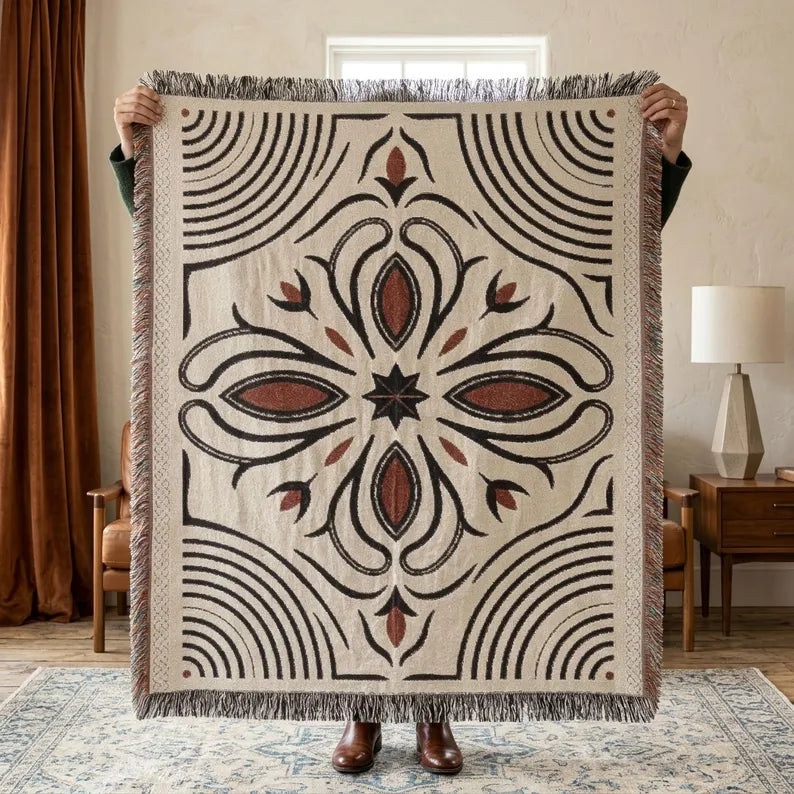 Black and rust Western boot stitch woven throw blanket on a natural woven base