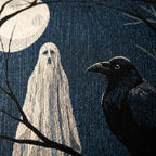 Close-up of ghost and raven artwork on the woven pillow fabric