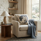 Koi fish woven pillow styled on a cream reading chair by a window