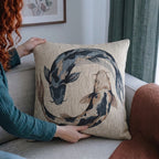 Person holding the 17 by 18 inch koi fish woven pillow for scale