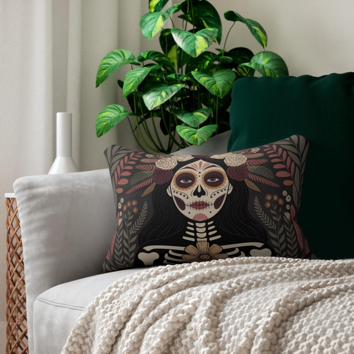 La Catrina Day of the Dead lumbar pillow styled on a green and cream chair