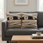 Pair of mummy eyes woven Halloween pillows in a collected interior