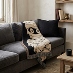Mummy woven throw blanket draped over a gray sectional sofa