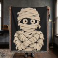 Person holding a black and cream mummy woven throw blanket