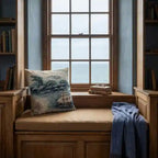 Vintage sea serpent map woven cushion in a coastal reading nook