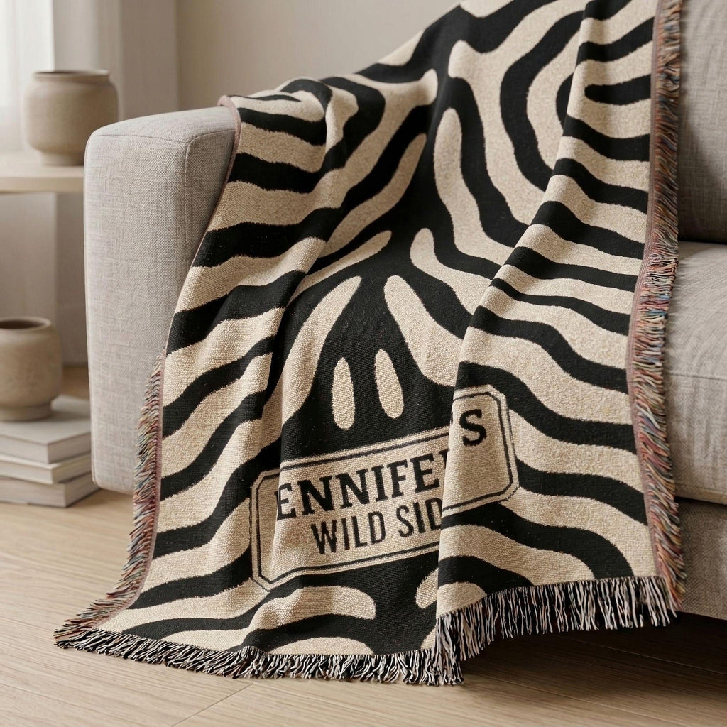 Personalized black and cream zebra print woven blanket styled on a green chair
