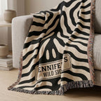 Personalized black and cream zebra print woven blanket styled on a green chair