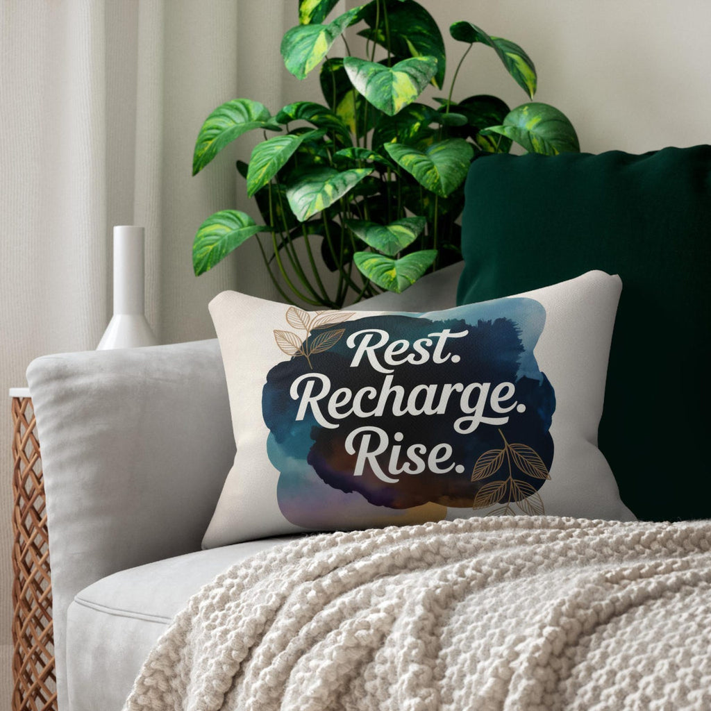 Rest Recharge Rise affirmation pillow on a green and cream accent chair